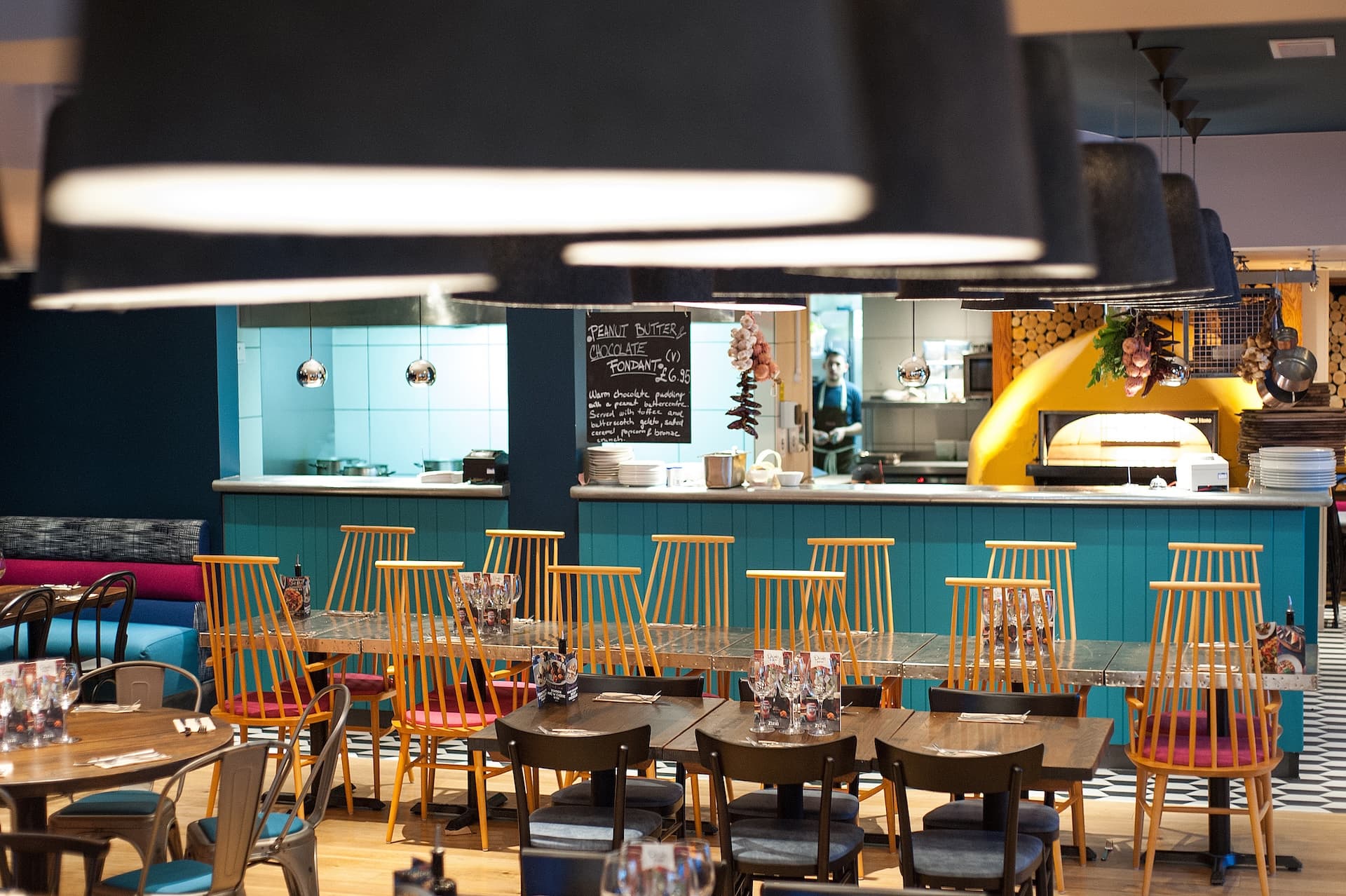 Interior view of Zizzi Solihull's, lively mural backdrop with stylish seating.