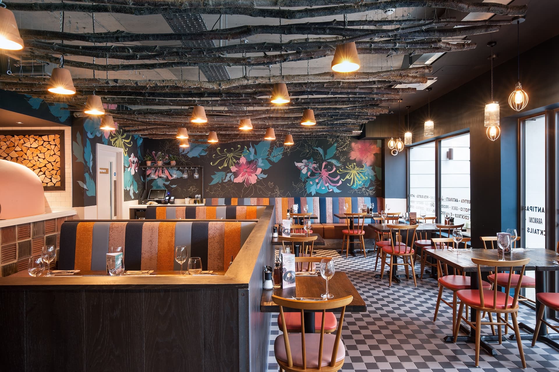 Inside Zizzi Bath dining area featuring wooden tables and striped booths