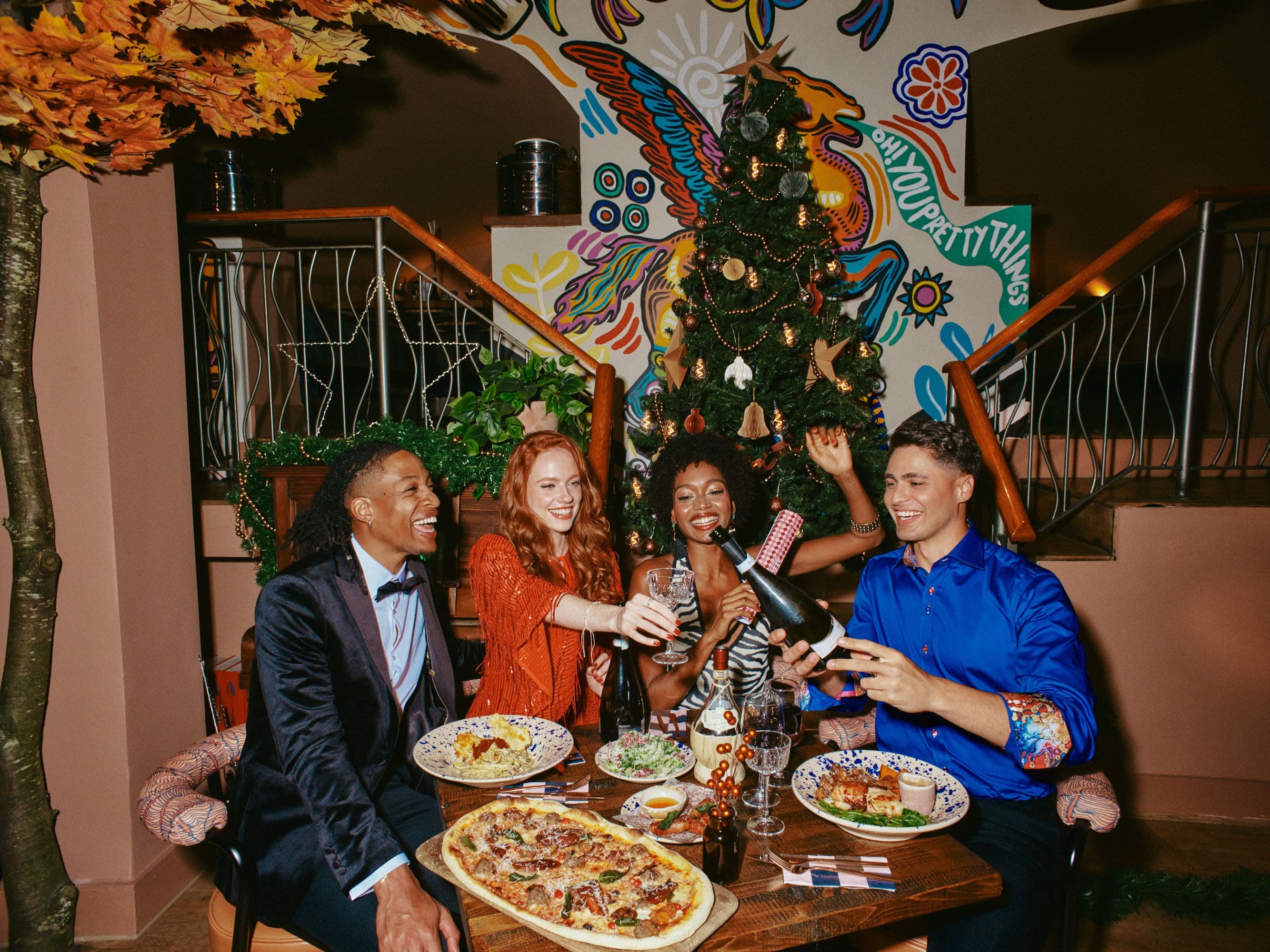 Friends celebrating Christmas at the table with food and drink