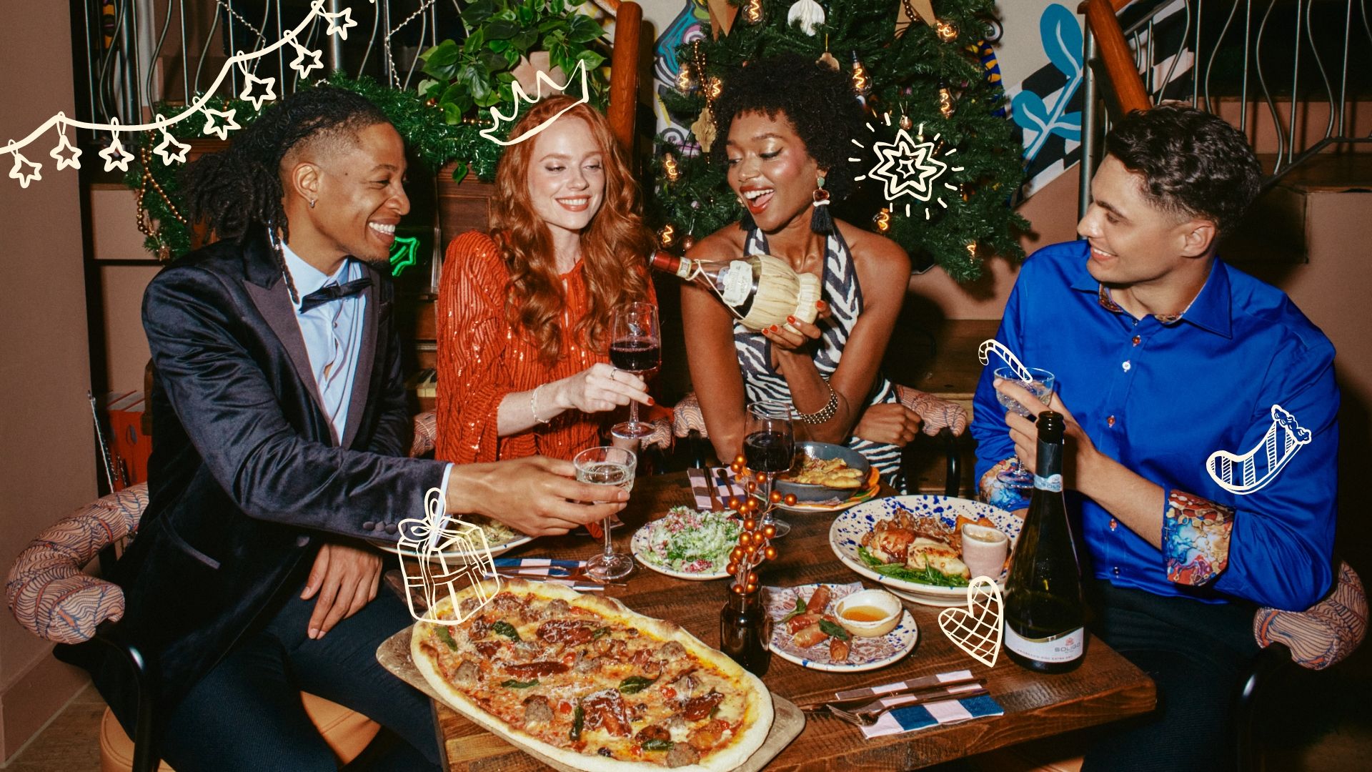 Friends celebrating Christmas at the table with food and drink 