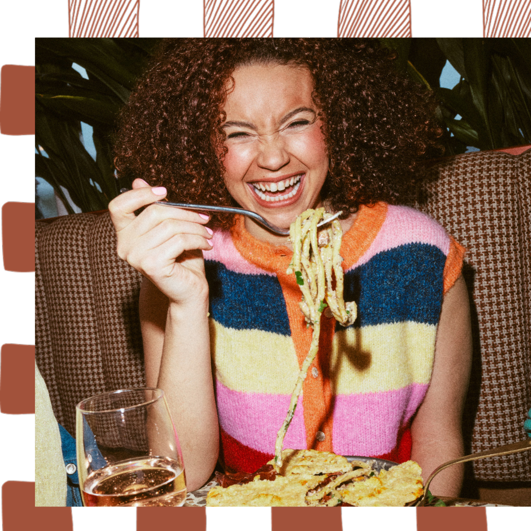 Woman twirling fresh Cacio e Pepe and smiling 