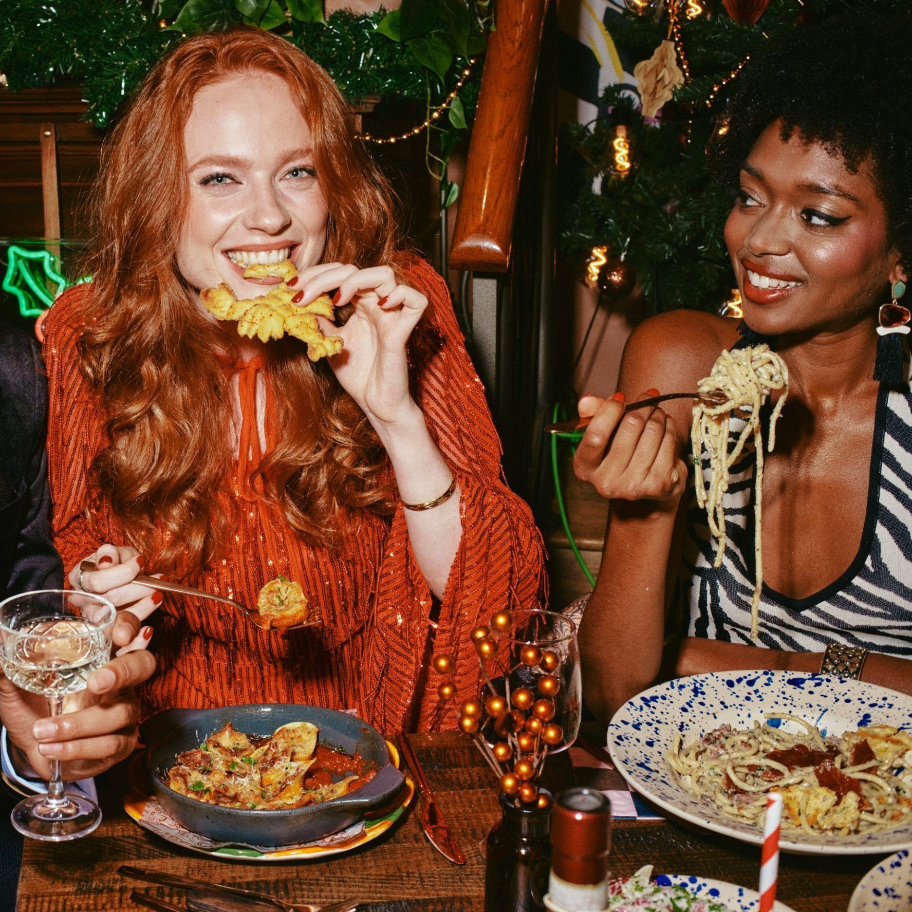 A couple of people enjoying their Christmas pasta dishes 