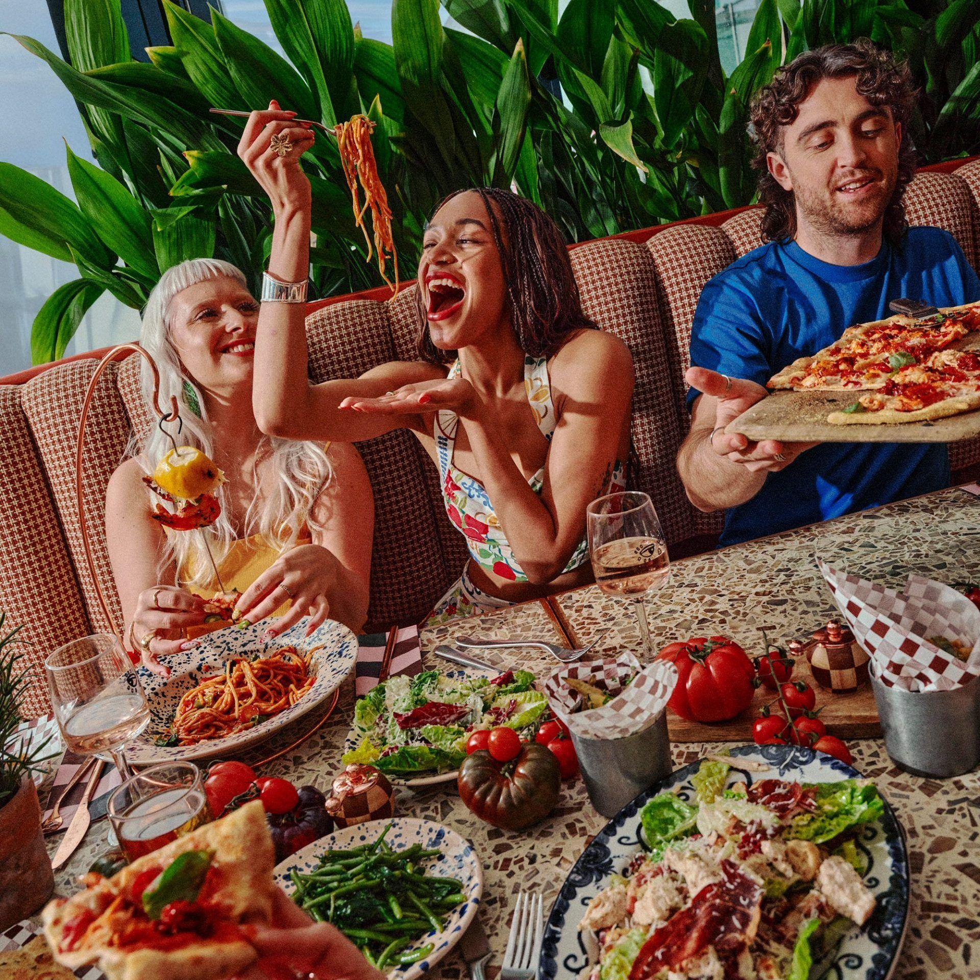 Group shot of people eating food around the table 